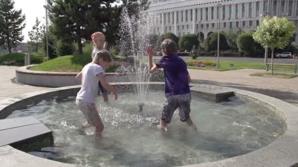 Children stand knee-deep in the fountain. — Stock Video