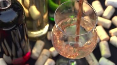 Pembe şarap bir bardak dökülür.