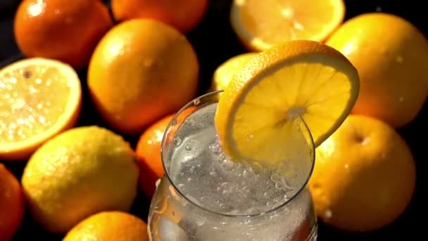 Vallende ijsblokjes in een Citrus drankje. — Stockvideo