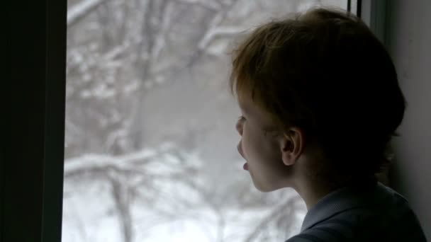 Junge schaut auf Schnee — Stockvideo