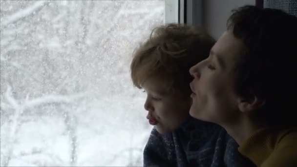 Madre con hijo mirando por la ventana — Vídeo de stock