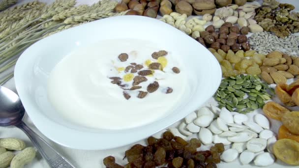 Roggen und Cornflakes fallen in eine Schüssel mit Milch. — Stockvideo