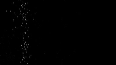 Siyah bir zemin üzerine beyaz parçacıklar