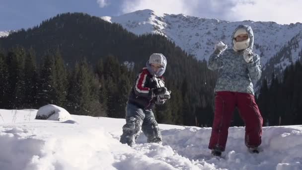 Niños lanzando bolas de nieve — Vídeo de stock