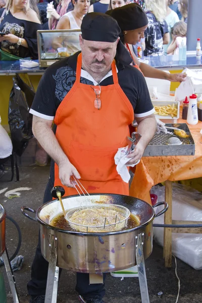 Homem fazendo comida no stand do mercado de rua — Fotografia de Stock