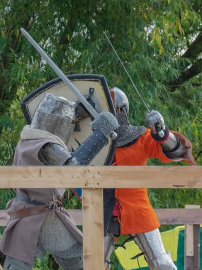 Orta Çağ zırhlı 60 santimlik savaşçılar arenada savaşıyor. Kılıçlarla donatılmış. Demir miğferler ve kalkanlar tarafından korunuyorlar. Ortaçağ Avrupa şövalye turnuvalarının tarihi yeniden yapılandırması