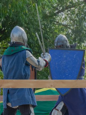 Orta Çağ zırhlı 60 santimlik savaşçılar arenada savaşıyor. Kılıçlarla donatılmış. Demir miğferler ve kalkanlar tarafından korunuyorlar. Ortaçağ Avrupa şövalye turnuvalarının tarihi yeniden yapılandırması