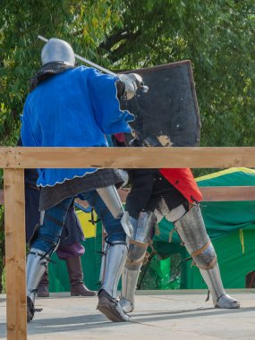 Orta Çağ zırhlı 60 santimlik savaşçılar arenada savaşıyor. Kılıçlarla donatılmış. Demir miğferler ve kalkanlar tarafından korunuyorlar. Ortaçağ Avrupa şövalye turnuvalarının tarihi yeniden yapılandırması