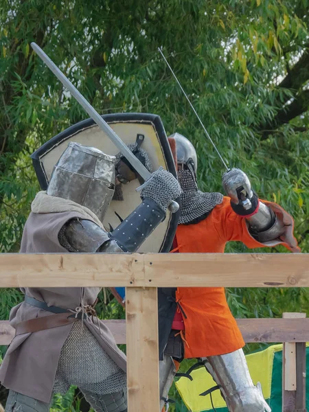 Orta Çağ zırhlı 60 santimlik savaşçılar arenada savaşıyor. Kılıçlarla donatılmış. Demir miğferler ve kalkanlar tarafından korunuyorlar. Ortaçağ Avrupa şövalye turnuvalarının tarihi yeniden yapılandırması