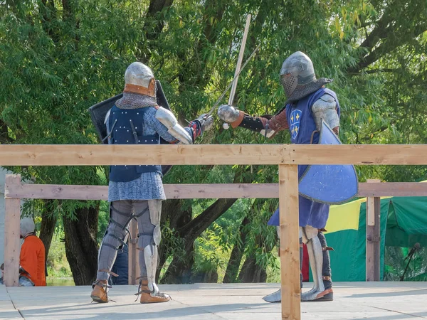 Orta Çağ zırhlı 60 santimlik savaşçılar arenada savaşıyor. Kılıçlarla donatılmış. Demir miğferler ve kalkanlar tarafından korunuyorlar. Ortaçağ Avrupa şövalye turnuvalarının tarihi yeniden yapılandırması