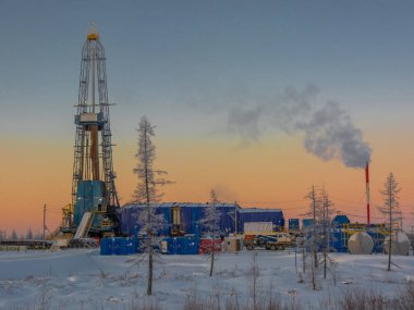 Kuzey tarlasında petrol ve gaz kuyuları kazıyor. Kutup dondurucu soğuk günü. Bir sondaj teçhizatıyla karda kış ormanı-tundra manzarası. Güzel gökyüzü