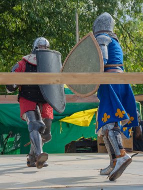 Orta Çağ zırhlı 60 santimlik savaşçılar arenada savaşıyor. Kılıçlarla donatılmış. Demir miğferler ve kalkanlar tarafından korunuyorlar. Ortaçağ Avrupa şövalye turnuvalarının tarihi yeniden yapılandırması