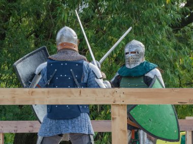 Orta Çağ zırhlı 60 santimlik savaşçılar arenada savaşıyor. Kılıçlarla donatılmış. Demir miğferler ve kalkanlar tarafından korunuyorlar. Ortaçağ Avrupa şövalye turnuvalarının tarihi yeniden yapılandırması