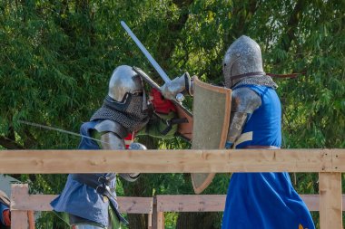 Orta Çağ zırhlı 60 santimlik savaşçılar arenada savaşıyor. Kılıçlarla donatılmış. Demir miğferler ve kalkanlar tarafından korunuyorlar. Ortaçağ Avrupa şövalye turnuvalarının tarihi yeniden yapılandırması