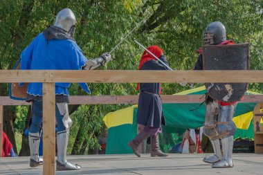 Orta Çağ zırhlı 60 santimlik savaşçılar arenada savaşıyor. Kılıçlarla donatılmış. Demir miğferler ve kalkanlar tarafından korunuyorlar. Ortaçağ Avrupa şövalye turnuvalarının tarihi yeniden yapılandırması