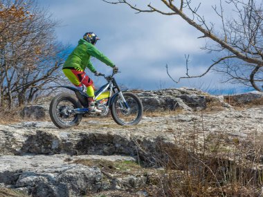 Pyatigorsk / Rusya - 26 Mart 2021: Dağlık bir bölgede motosiklet denemeleri yapan bir sporcunun eğitimi. Bir adam özel bir motosikletle dağ engellerini aşmakla meşgul.