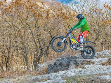 Pyatigorsk / Rusya - 26 Mart 2021: Dağlık bir bölgede motosiklet denemeleri yapan bir sporcunun eğitimi. Bir adam özel bir motosikletle dağ engellerini aşmakla meşgul.