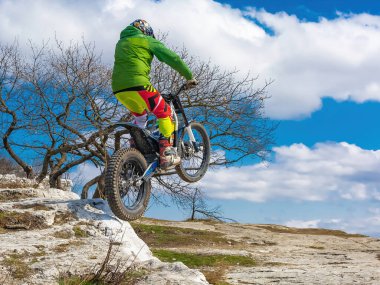 Pyatigorsk / Rusya - 26 Mart 2021: Dağlık bir bölgede motosiklet denemeleri yapan bir sporcunun eğitimi. Bir adam özel bir motosikletle dağ engellerini aşmakla meşgul.
