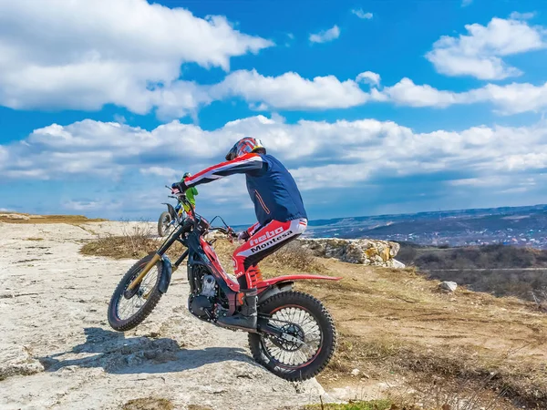 Pyatigorsk / Rusya - 26 Mart 2021: Dağlık bir bölgede motosiklet denemeleri yapan bir sporcunun eğitimi. Bir adam özel bir motosikletle dağ engellerini aşmakla meşgul.