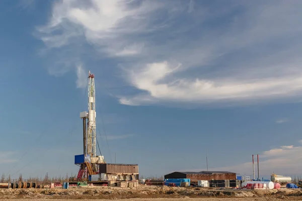 A site in the northern tundra at an oil and gas field. Drilling rig for drilling wells. Infrastructure and drilling equipment for drilling operations. Beautiful expressive sky