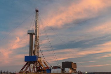 Kuzey tundrada bir petrol ve gaz sahasında. Sondaj kuyuları için sondaj kulesi. Sondaj işlemleri için altyapı ve sondaj ekipmanları. Güzel anlamlı gökyüzü