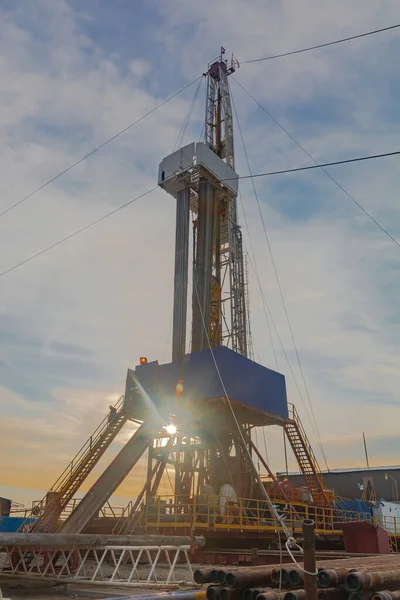 A site in the northern tundra at an oil and gas field. Drilling rig for drilling wells. Infrastructure and drilling equipment for drilling operations. Beautiful expressive sky