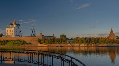 Gün batımında Pskov Kremlin manzarası. Önde Neman sınır nehri var. Metin büyük harflerle yazılmıştır. Rusya buradan başlar.