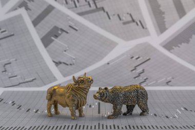 Hisse senedi fiyatlarının arka planında metalik sarı boğa ve ayı figürleri var. Ticaret sembollerini değiş tokuş edin. Para ve menkul kıymetler piyasasında alıcılar ve satıcılar arasındaki mücadele kavramı
