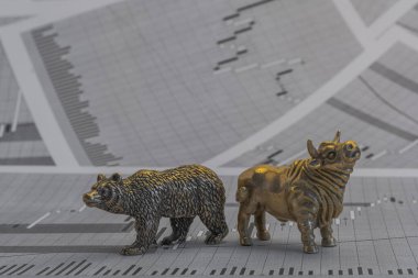 Hisse senedi fiyatlarının arka planında metalik sarı boğa ve ayı figürleri var. Ticaret sembollerini değiş tokuş edin. Para ve menkul kıymetler piyasasında alıcılar ve satıcılar arasındaki mücadele kavramı