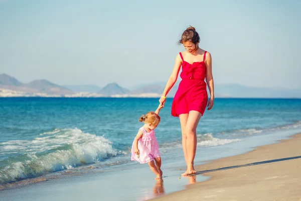 Mor och dotter går på stranden — Stockfoto