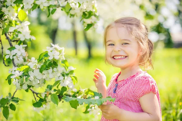 Lycklig liten flicka i äppelträd trädgård — Stockfoto