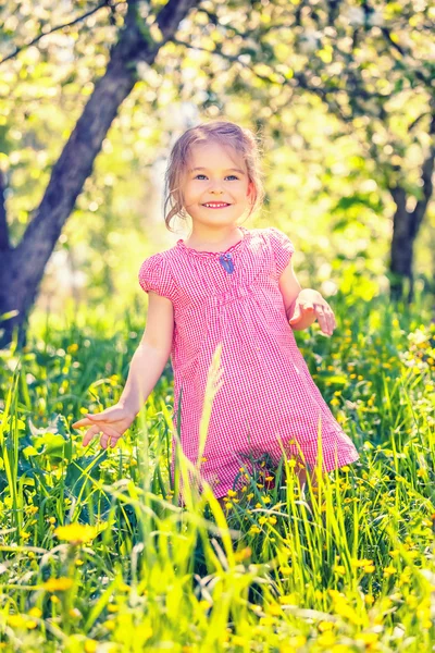 Šťastná holčička na jarní zahradě — Stock fotografie