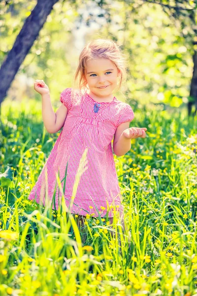 Lycklig liten flicka i vår trädgård — Stockfoto