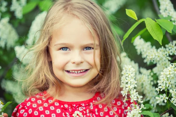 Liten flicka i vårblommor — Stockfoto