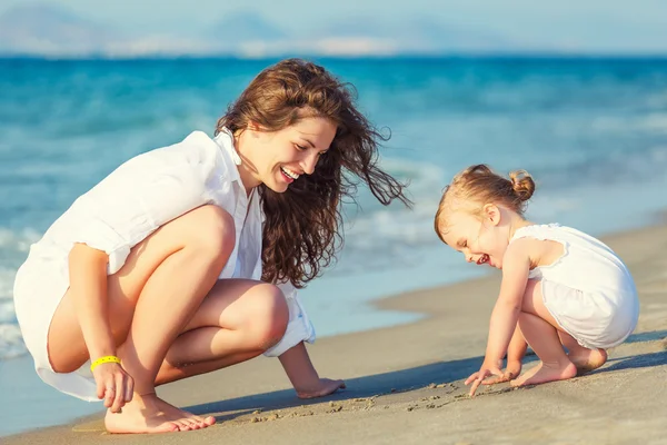 Mor och dotter leker på stranden — Stockfoto