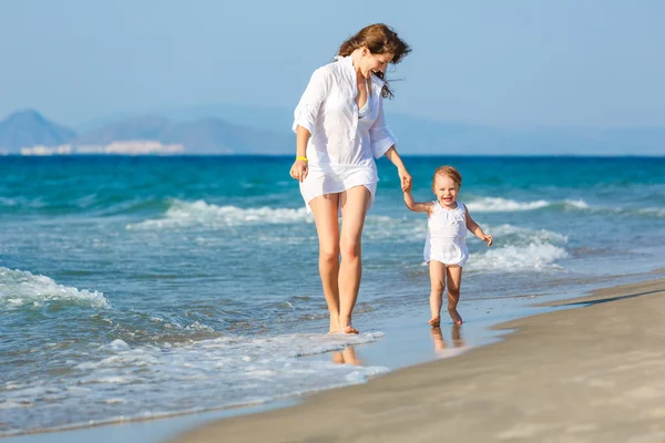 Mother and daughter walking on the beach — Stock Photo, Image