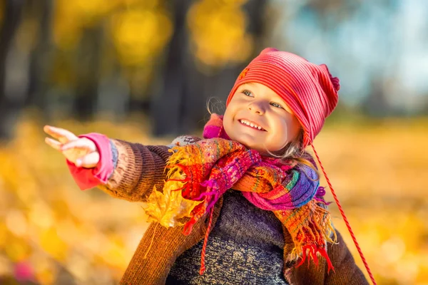 小さな女の子が紅葉で遊んで — ストック写真