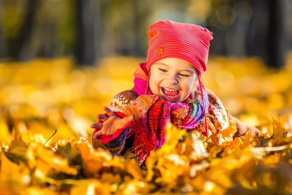 Menina brincando com folhas de outono — Fotografia de Stock