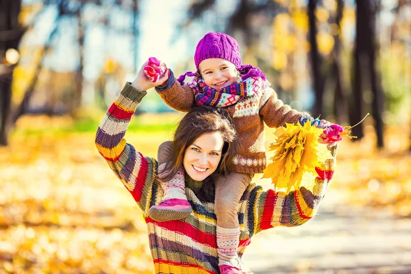 Mother and daughter playing in autumn park — Stock Photo, Image