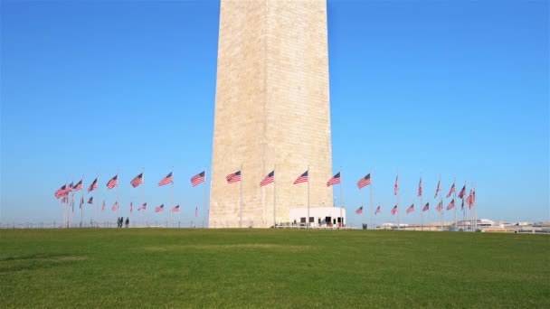 Banderas de los Estados Unidos cerca del monumento de Washington ondeando sobre el cielo azul — Vídeo de stock