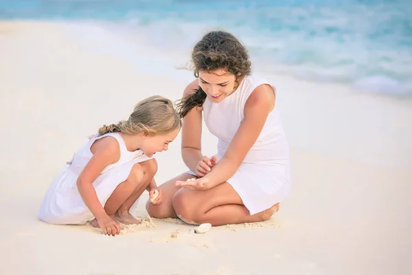 Мать и маленькая дочь играют на пляже на Мальдивах во время летних каникул — стоковое фото
