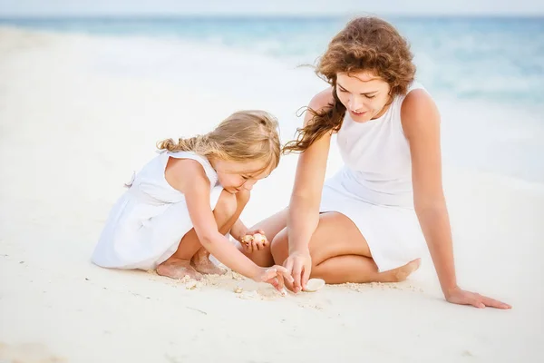 Mor och liten dotter leker på stranden på Maldiverna på sommarsemester — Stockfoto