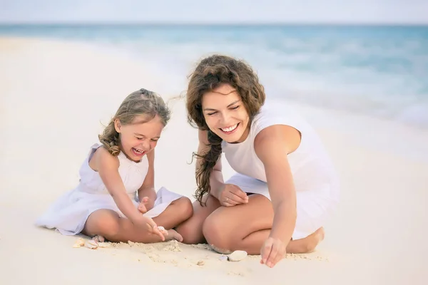 Мама з донькою бавляться на пляжі на Мальдівах під час літніх канікул. — стокове фото