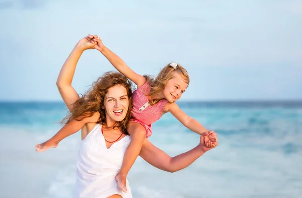 Mãe e filha felizes na praia do oceano nas Maldivas nas férias de verão — Fotografia de Stock