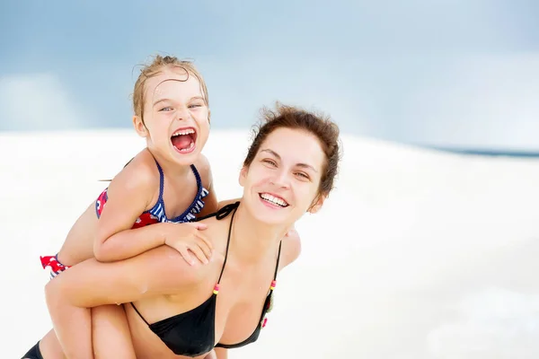 여름 방학 때 몰디브의 바닷가에서 행복 한 어머니와 딸 스톡 사진