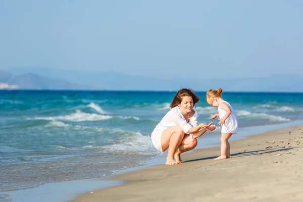 Mother and daughter playing on the beach — Stock Photo, Image