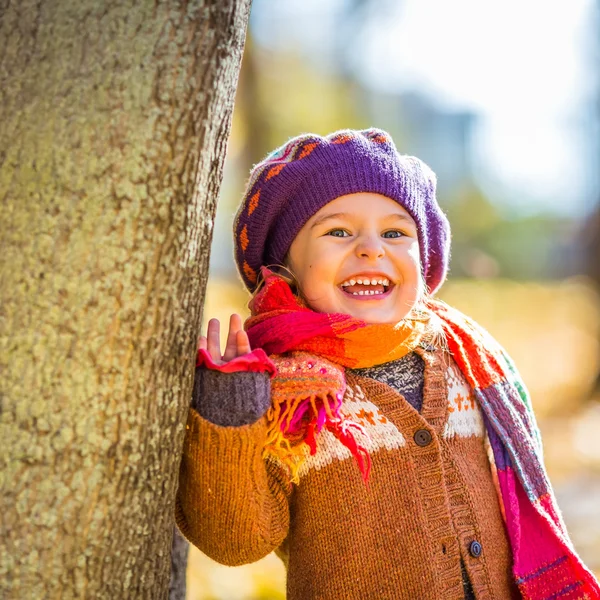 Glad liten flicka som leker i parken hösten — Stockfoto