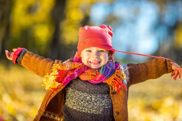 Glad liten flicka som leker i parken hösten — Stockfoto