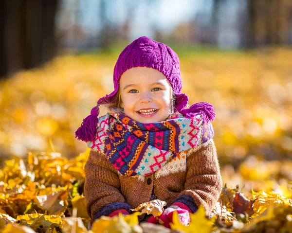 Glad liten flicka som leker i parken hösten — Stockfoto