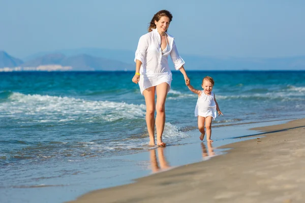 Mother and daughter walking on the beach — Stock Photo, Image